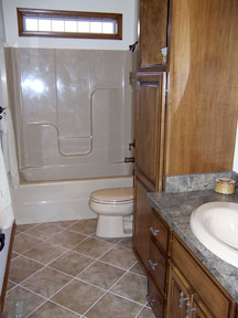 bath with tile flooring and custom glass block window